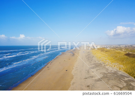 People walking on a north sea sandy beach near Zandvoort, Netherlands, aerial drone view 61669504