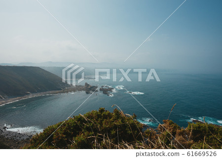 Misty rocky ocean coast line 61669526