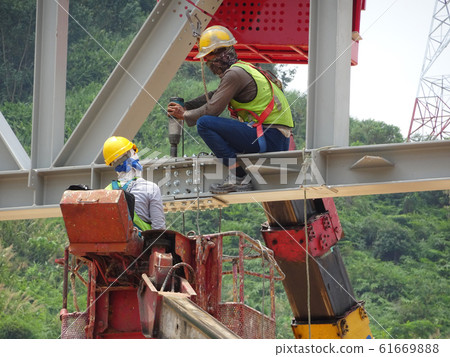 Construction workers working at height installing the steel structure. Steel structure able to provide huge and long span for the building. 61669888