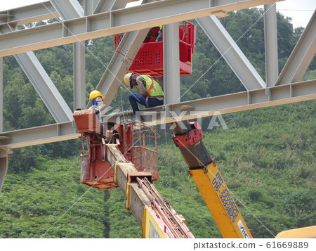 Construction workers working at height installing the steel structure. Steel structure able to provide huge and long span for the building. 61669889