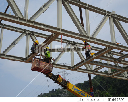 Construction workers working at height installing the steel structure. Steel structure able to provide huge and long span for the building. 61669891