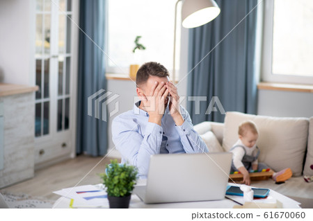 Bearded man in a blue shirt having a headache 61670060