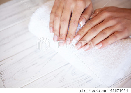 Woman Hand Care. Closeup Of Beautiful Female Hands Having Spa Manicure At Beauty Salon. Beautician Filing Clients Healthy Natural Nails With Nail File. Nail Treatment 61671694