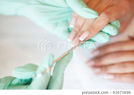 Manicure salon. Woman in nail salon receiving manicure 61671696