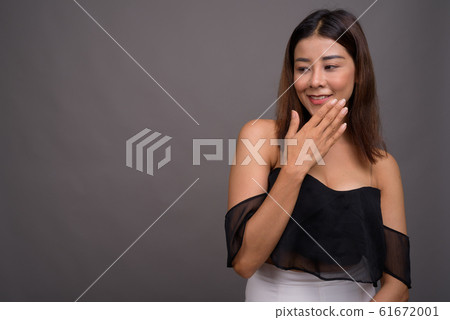 Young beautiful Asian woman against gray background 61672001