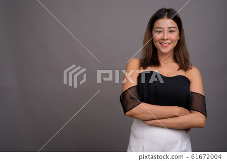 Young beautiful Asian woman against gray background Young beautiful Asian woman against gray background 61672004