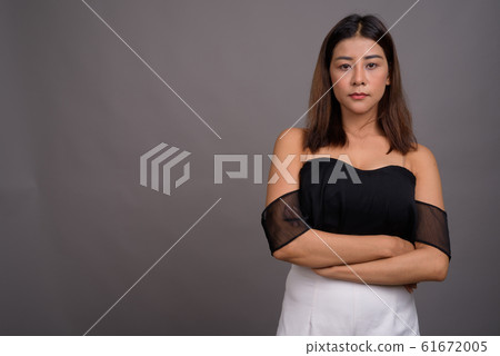 Young beautiful Asian woman against gray background Young beautiful Asian woman against gray background 61672005