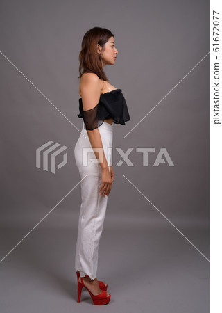 Young beautiful Asian woman against gray background Young beautiful Asian woman against gray background 61672077