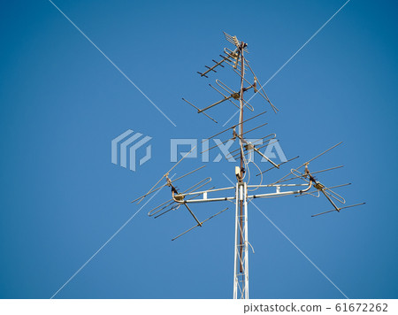 Old television antenna signal transmission on sky blue. Old television antenna signal transmission on sky blue. 61672262