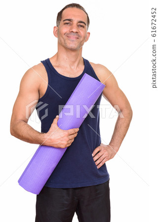 Mature happy Persian man holding yoga mat ready for gym Mature happy Persian man holding yoga mat ready for gym 61672452