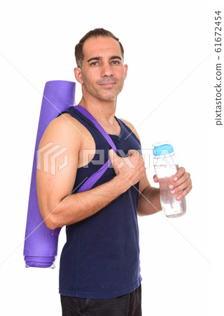 Mature handsome Persian man holding yoga mat and water bottle Mature handsome Persian man holding yoga mat and water bottle 61672454