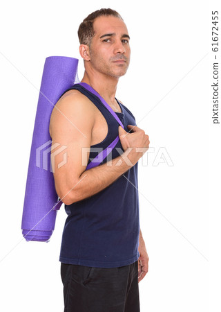 Mature handsome Persian man holding yoga mat ready for gym 61672455