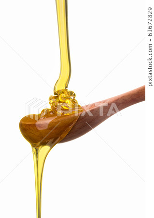Falling and flowing honey on a wooden spoon isolated on white with clipping path Falling and flowing honey on a wooden spoon isolated on white with clipping path 61672829