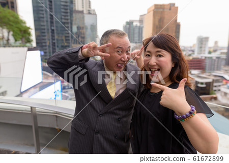 Mature Asian businessman and mature Asian woman exploring the city together 61672899