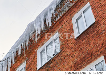 icicles on the roof of a brick house icicles on the roof of a brick house 61673284