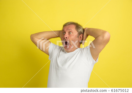 Caucasian senior man's portrait isolated on yellow studio background 61675012