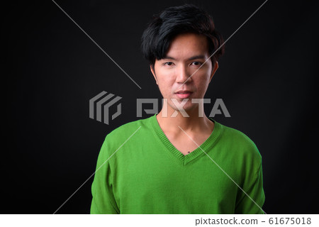 Young handsome Asian man against black background 61675018