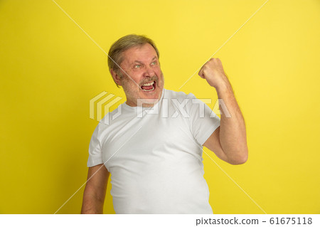 Caucasian senior man's portrait isolated on yellow studio background Caucasian senior man's portrait isolated on yellow studio background 61675118