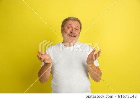 Caucasian senior man's portrait isolated on yellow studio background Caucasian senior man's portrait isolated on yellow studio background 61675148