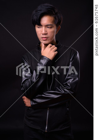 Young handsome Asian man against black background Young handsome Asian man against black background 61675748