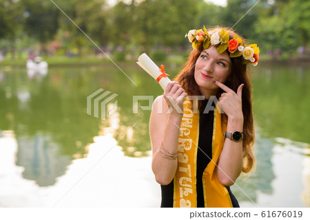 Young beautiful woman celebrating graduation at the park in Bang 61676019