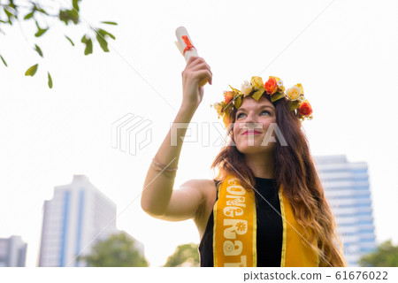 Young beautiful woman celebrating graduation at the park in Bang 61676022
