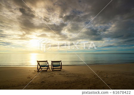 Two Beach Chairs standing in beach with beautiful Two Beach Chairs standing in beach with beautiful 61678422