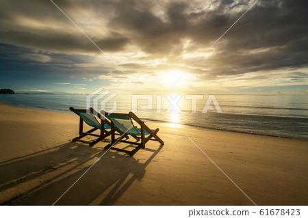 Two Beach Chairs standing in beach with beautiful Two Beach Chairs standing in beach with beautiful 61678423
