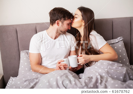 Loving couple relaxing in bed at home 61678762