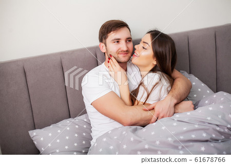 Loving couple relaxing in bed at home Loving couple relaxing in bed at home 61678766