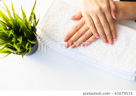 Nails care. Beautiful woman's nails with french manicure, in beauty studio 61679535