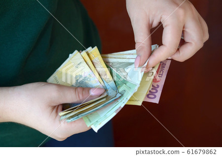 Female hands counts big amount of ukrainian money Female hands counts big amount of ukrainian money 61679862