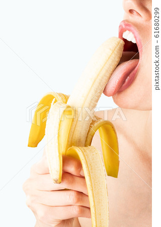 Close-up of sexy woman eating banana isolated on blue. 61680299