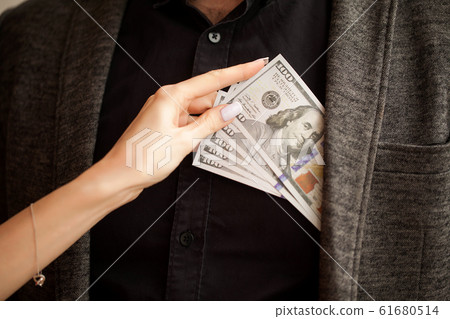 Business. Women's Hand Gives Money to Male. Woman Gives Bribe. B 61680514