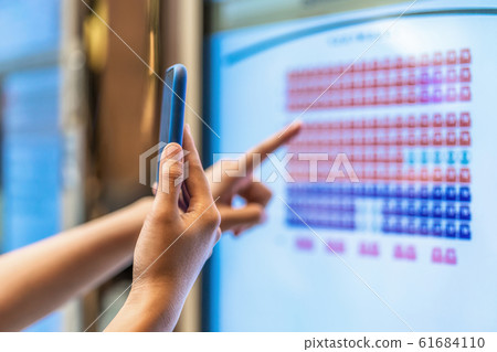 Closeup asian young woman hand using smart mobile phone scanning the movie tickets machine for buy and get the coupon in department store,lifestyle and leisure,entertain and technology scanner concept 61684110