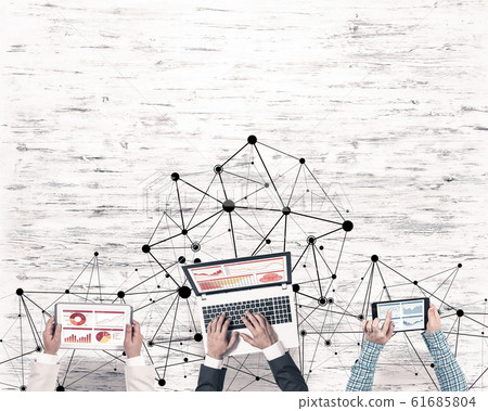 Top view of businesspeople sitting at table and using gadgets Top view of businesspeople sitting at table and using gadgets 61685804