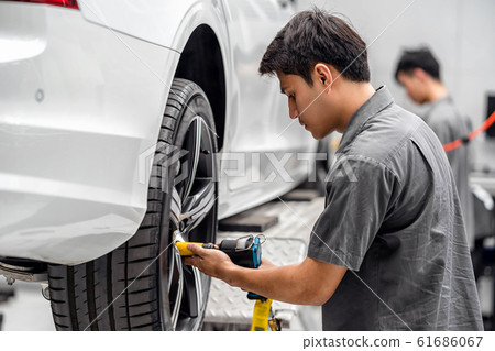 Asian mechanics checking the car wheels at maintainance service center for in showroom which is a part of showroom, technician or engineer professional work for customer, car repair concept 61686067