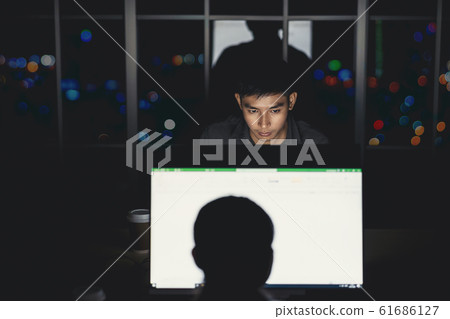 Asian businessman working hard late with her technology laptop in office, customer service and call center department,hard worker and overtime,team work with colleagues for success achievement concept 61686127
