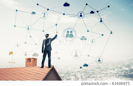 Businessman on house roof presenting networking and connection c 61686975