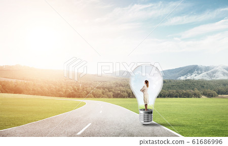 Businesswoman inside light bulb Businesswoman inside light bulb 61686996