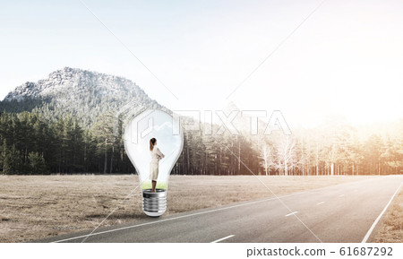 Businesswoman inside light bulb Businesswoman inside light bulb 61687292