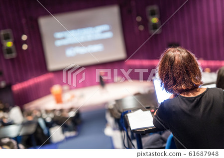 Audience in the lecture hall attending business conference event. 61687948