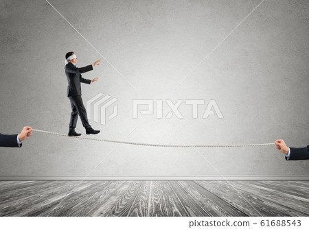 Business concept of risk support and assistance with man balancing on rope Business concept of risk support and assistance with man balancing on rope 61688543