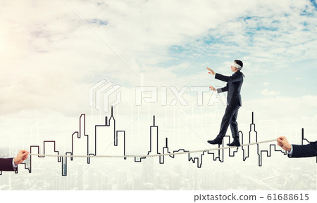 Business concept of risk support and assistance with man balancing on rope 61688615