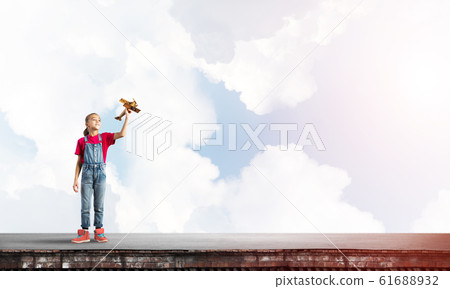 Concept of careless happy childhood with girl dreaming to become pilot Concept of careless happy childhood with girl dreaming to become pilot 61688932