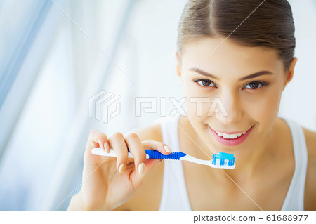 Health and Beauty. Beautiful Young Girl with White Teeth Holding a White Towel in Hands. A Woman With A Beautiful Smile. Tooth Health. Clean and Fresh Skin Health and Beauty. Beautiful Young Girl with White Teeth Holding a White Towel in Hands. A Woman With A Beautiful Smile. Tooth Health. Clean and Fresh Skin 61688977