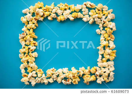 Food. Frozen Popcorn Corn Delicious Yellow Popcorn on Blue Background. Cinema. Copyspace. Place for Text Food. Frozen Popcorn Corn Delicious Yellow Popcorn on Blue Background. Cinema. Copyspace. Place for Text 61689073