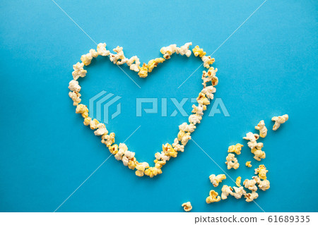 Food. Image of the Heart Forms from Popcorn. Delicious Popcorn on Blue Background. Cinema 61689335
