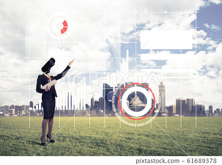 Camera headed woman standing on green grass against modern citys Camera headed woman standing on green grass against modern citys 61689378