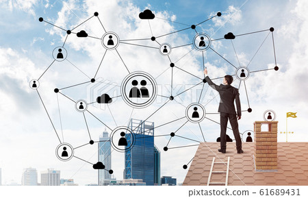 Businessman on house roof presenting networking and connection concept. Mixed media 61689431
